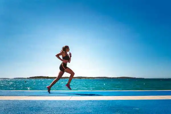 Woman running showing strong leg muscle Ashtead